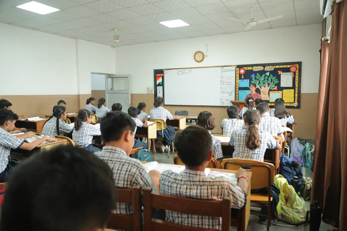 A senior class at work at their desks, the teacher at the board