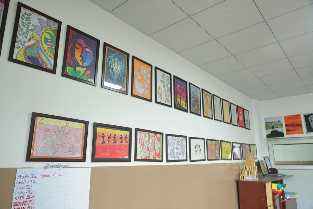 Student work framed along the art room wall