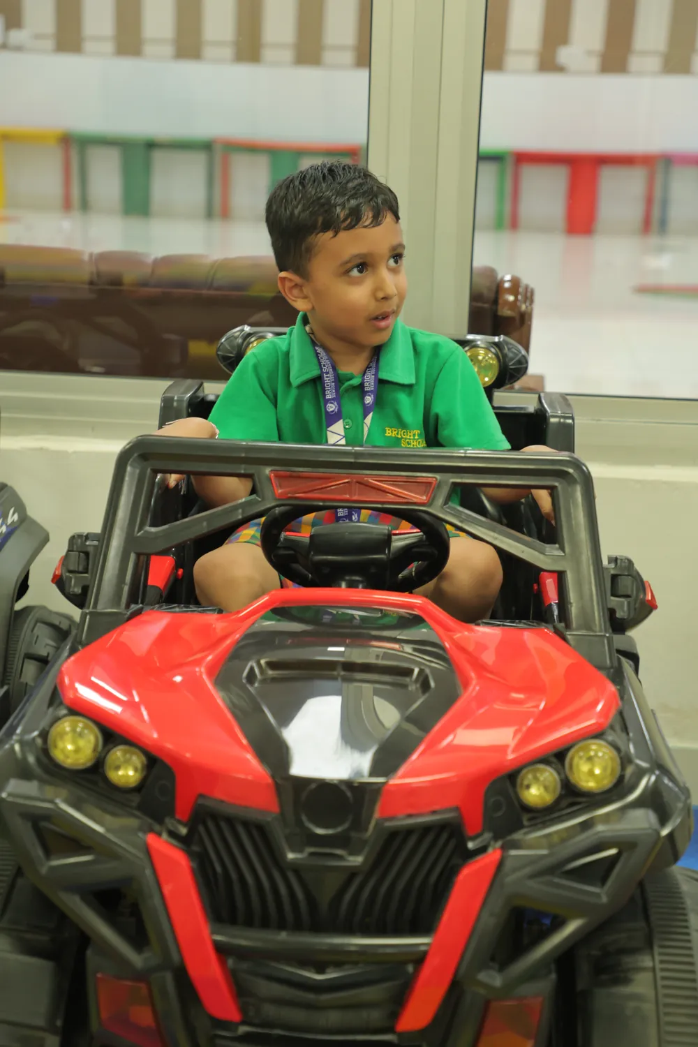 A boy at the wheel of a ride-on car