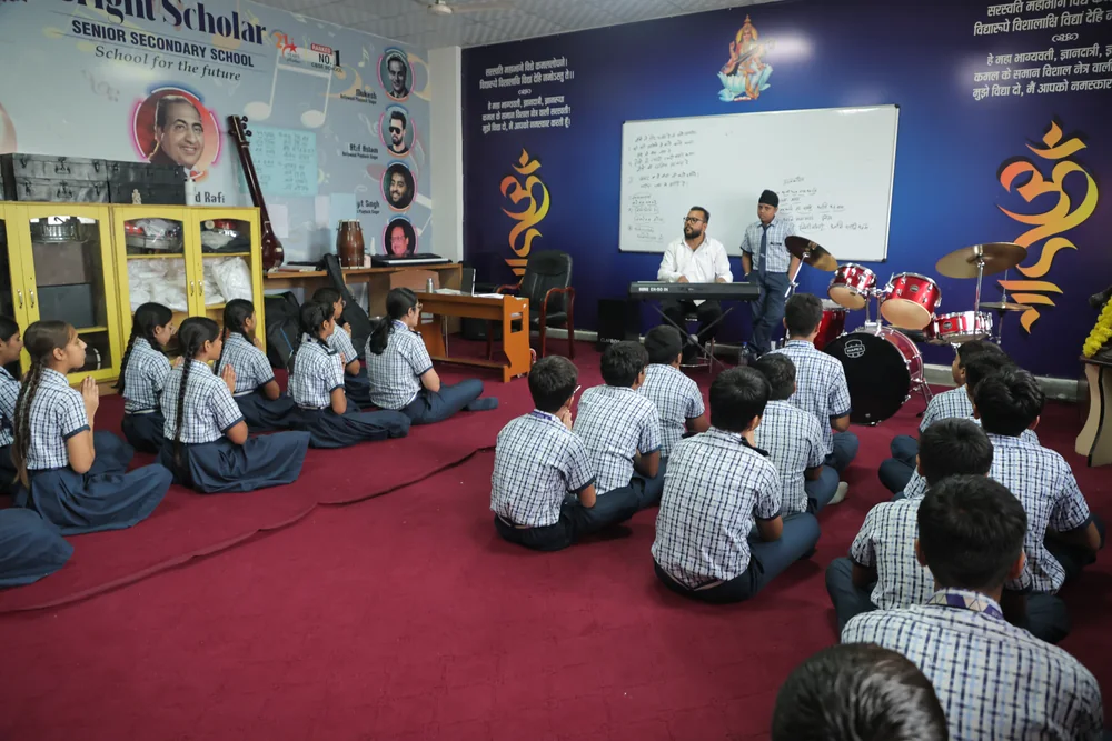 Students seated on the carpet of the seminar room, a teacher at the board