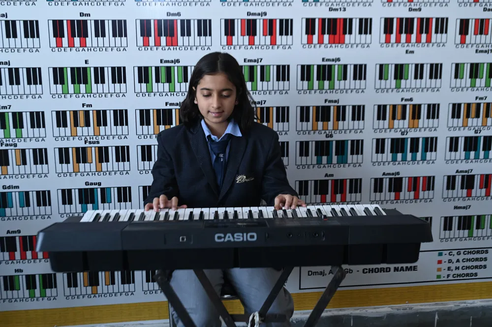 A student playing keyboard in the music room