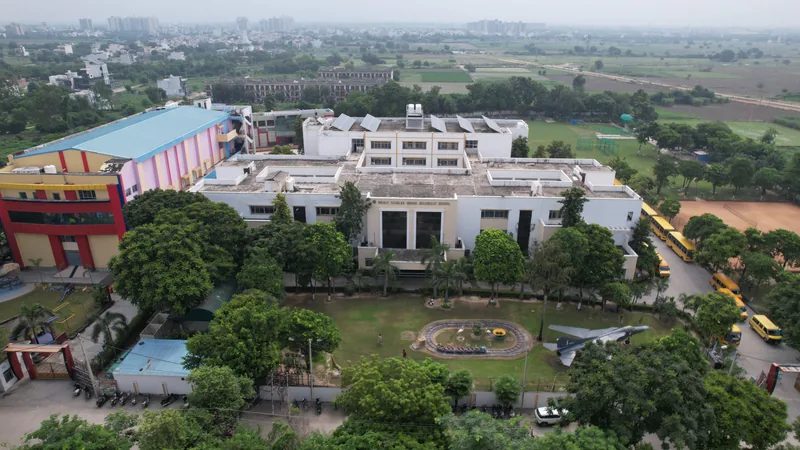 The campus from the air: the academic block, lawns, pool and buses among the trees
