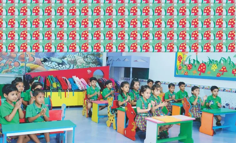 Pre-primary children clapping at their tables in the NIMBUS classroom