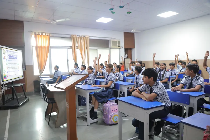 A classroom of hands raised to answer a question