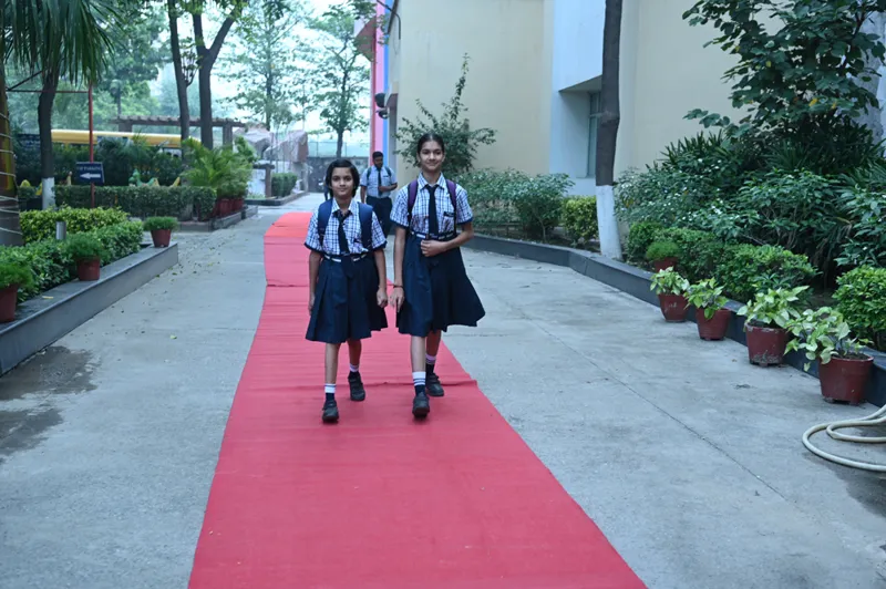Two students walking up the school driveway