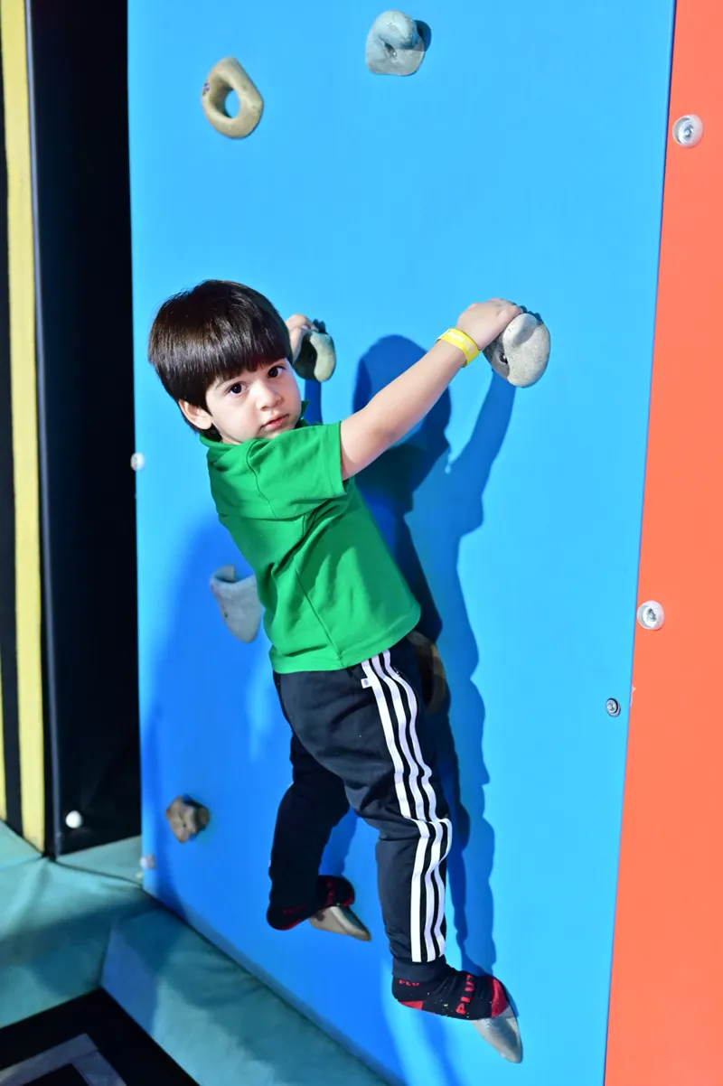 A child on the climbing wall in the play area