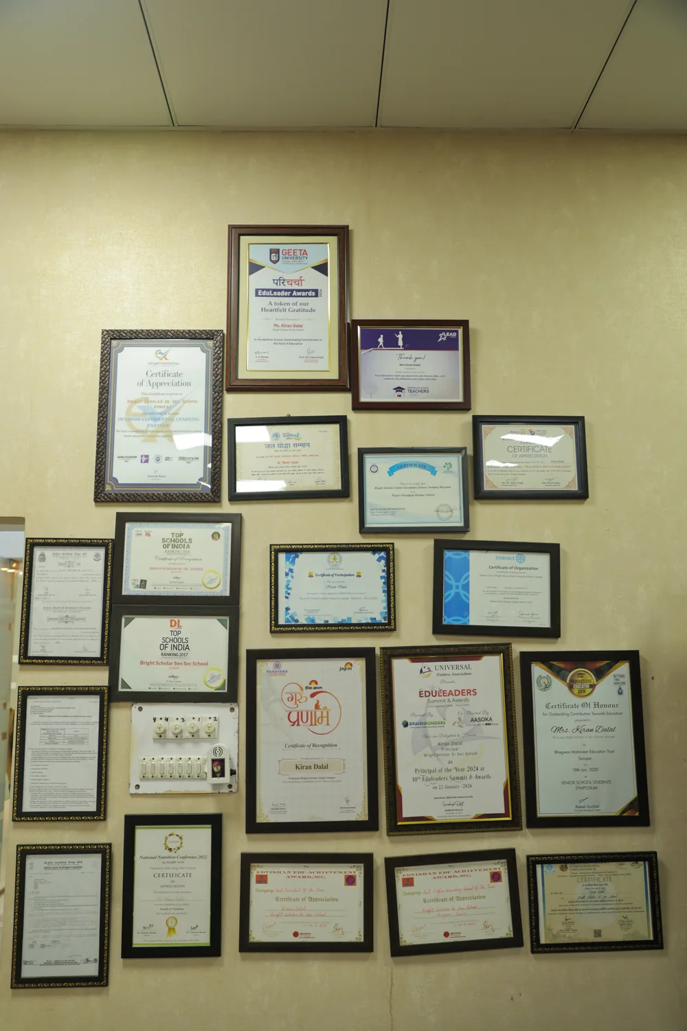 The wall of framed citations and awards in the Principal’s office